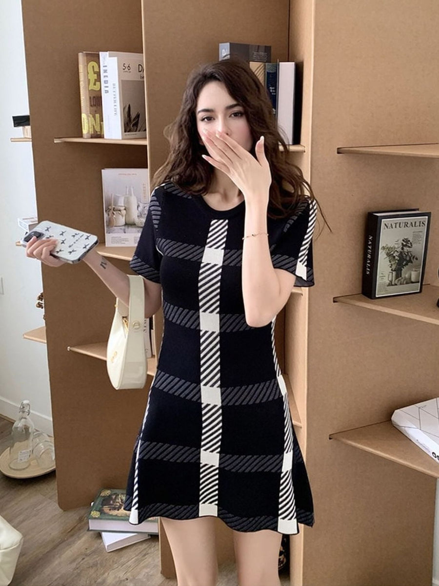 Black plaid mini dress with short sleeves and a crew neck, featuring a bold checkered pattern.