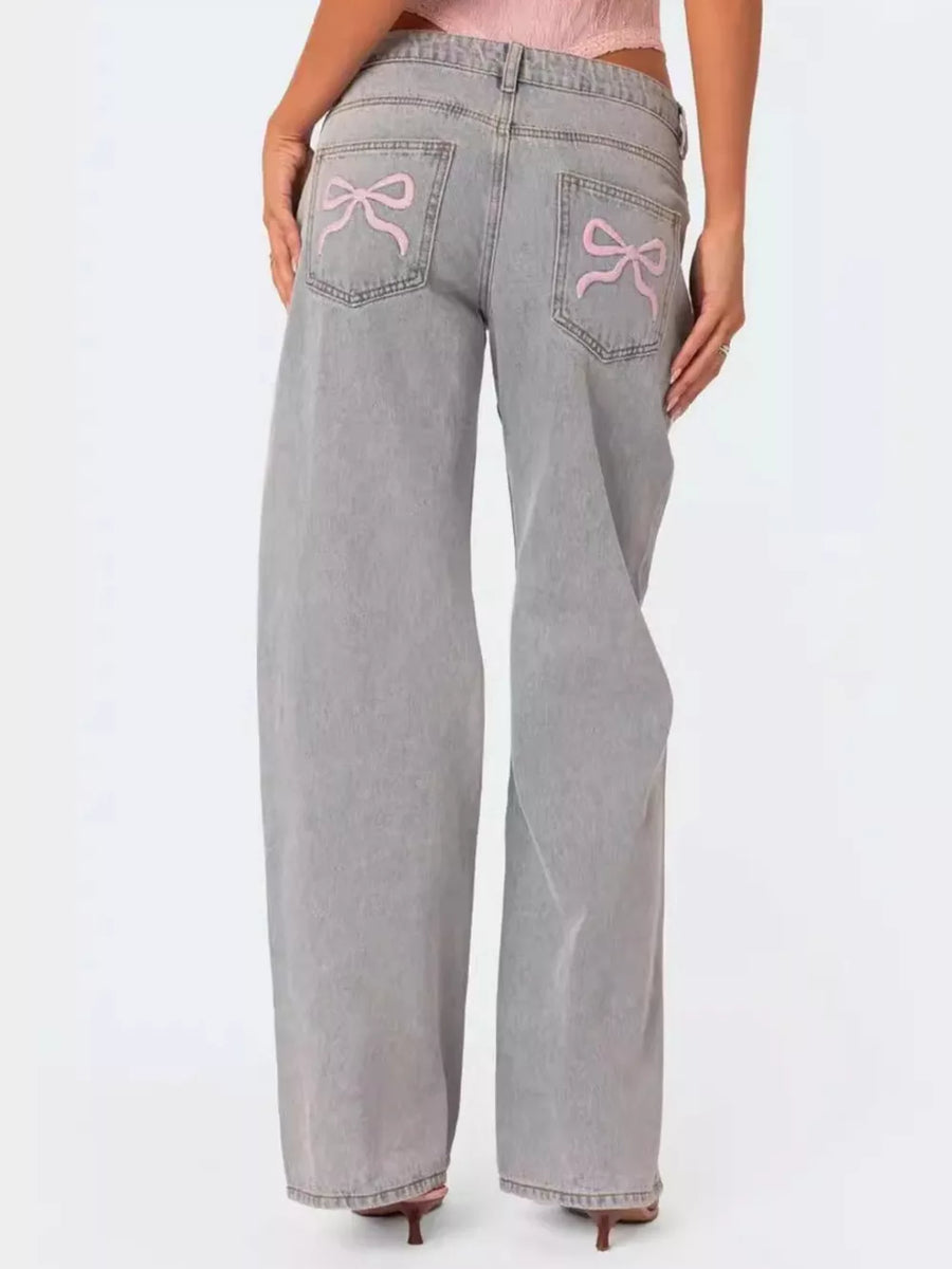 Light grey relaxed fit jeans with pink bow embroidery on back pockets.