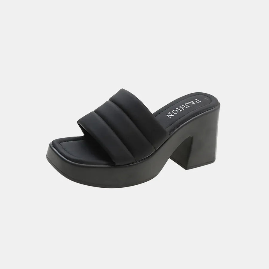 Black padded platform mules with a chunky block heel and square toe.