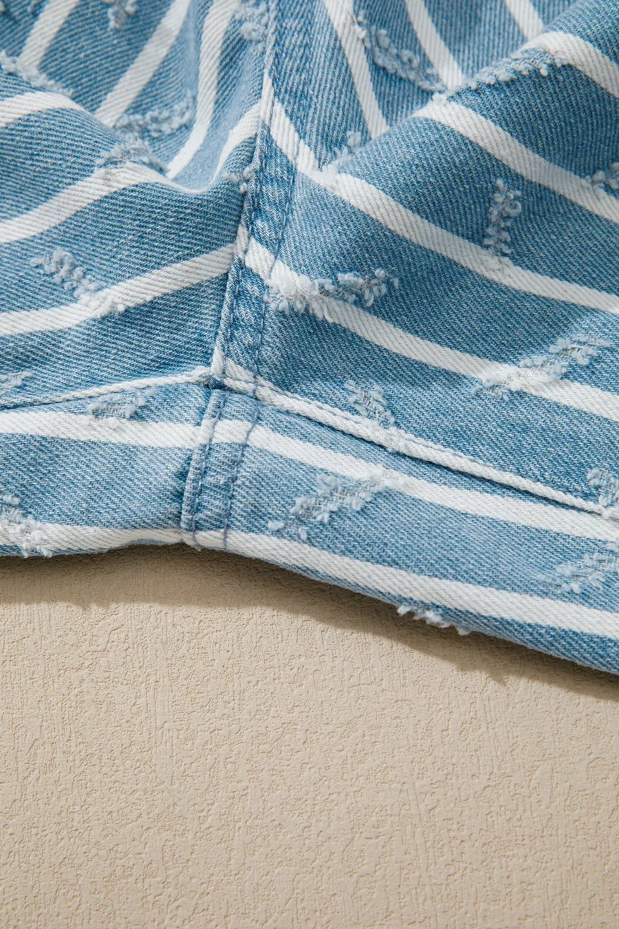 Striped distressed denim overalls with wide legs and frayed details.