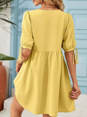 Yellow puff sleeve mini dress with tie detail on sleeves and tiered skirt.