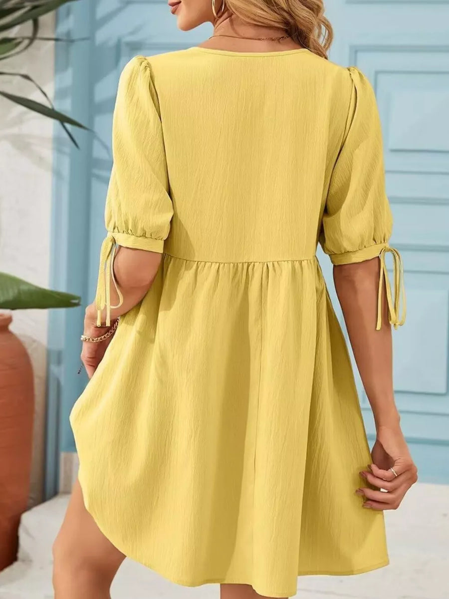 Yellow puff sleeve mini dress with tie detail on sleeves and tiered skirt.