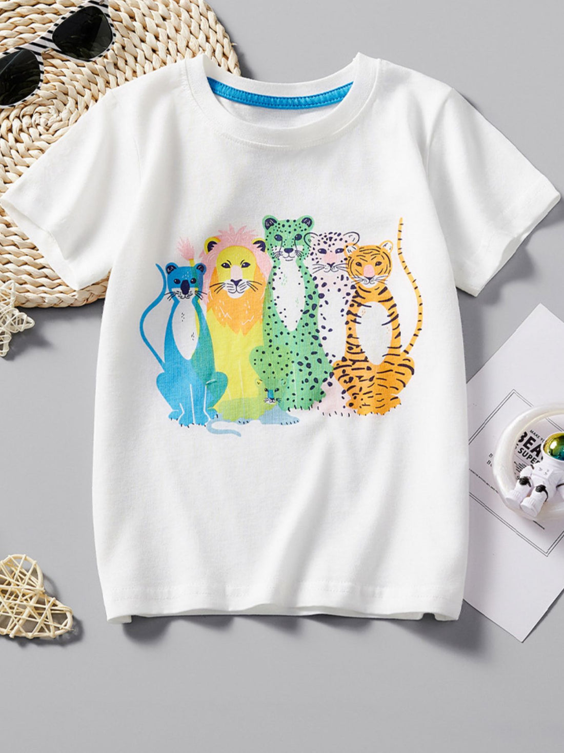 White cotton toddler t-shirt with colorful animal graphic and blue neckline trim.