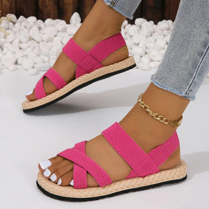 Hot Pink woven sole crossover sandals with elastic straps and espadrille trim.