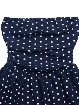 Navy polka dot strapless maxi dress with ruched bodice and A-line skirt.