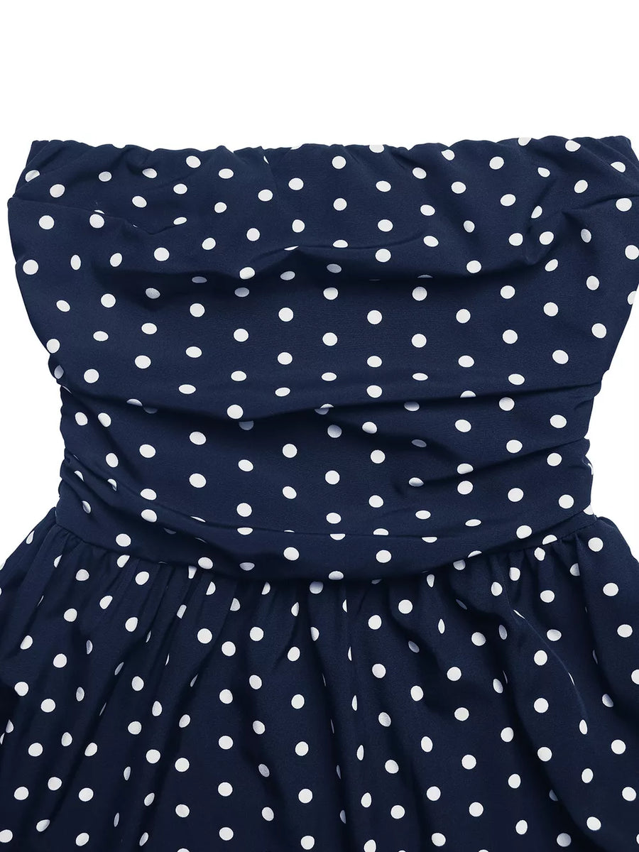Navy polka dot strapless maxi dress with ruched bodice and A-line skirt.