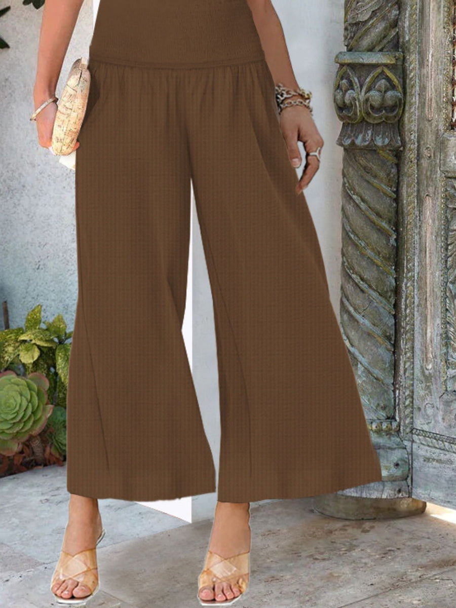 Smocked waist wide-leg pants in Light Brown with a textured fabric, styled with clear heels.