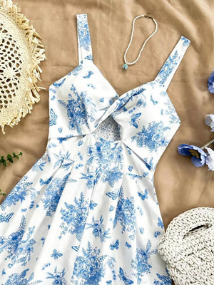 White floral print romper with blue flowers and butterflies, twist front, cutout, and smocked waist.
