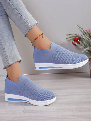 Light blue knit slip-on wedge sneakers with rainbow stripe detail and white sole.