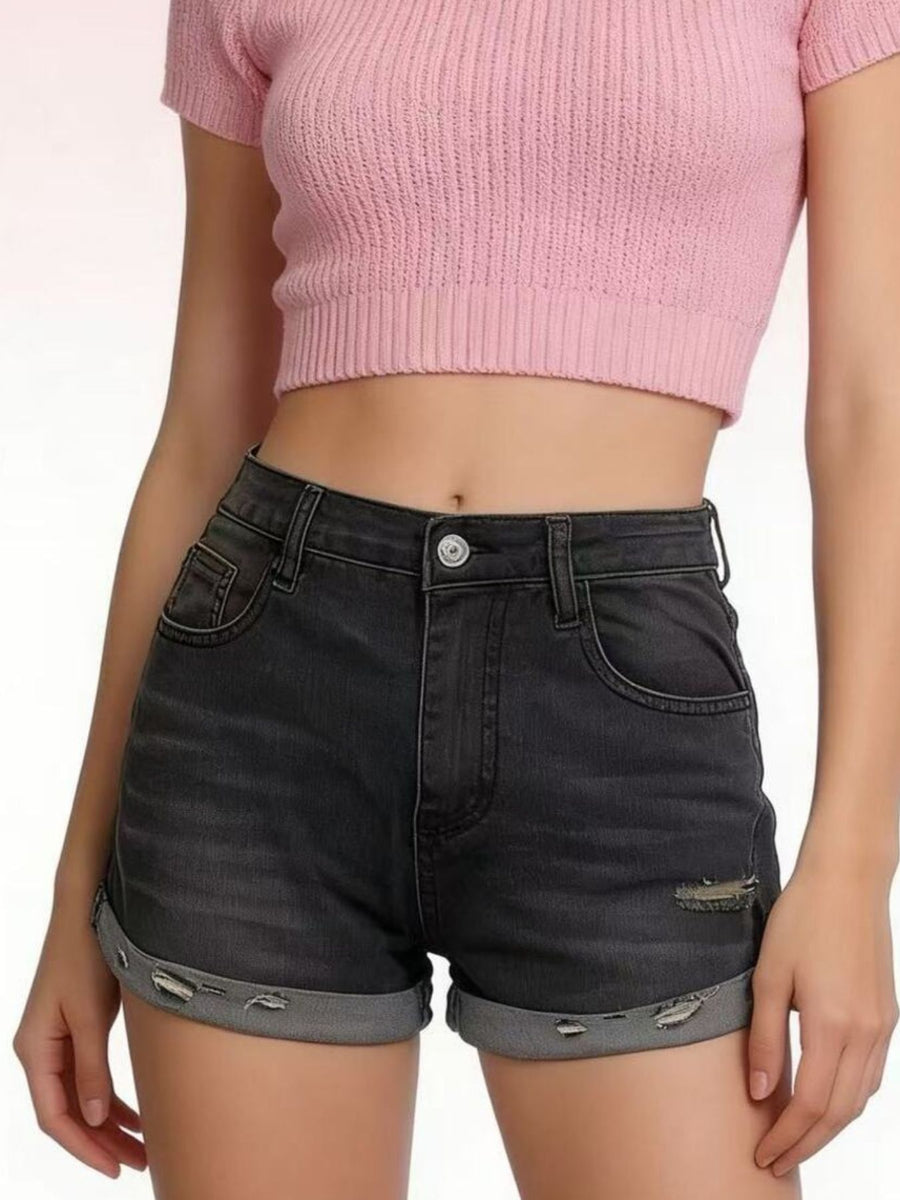 Black distressed denim roll-up shorts with button fly and cuffed hems.