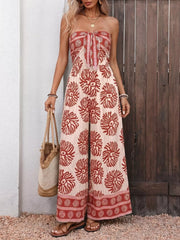 Charming floral tie-front wide-leg romper with strapless neckline and border print hem.