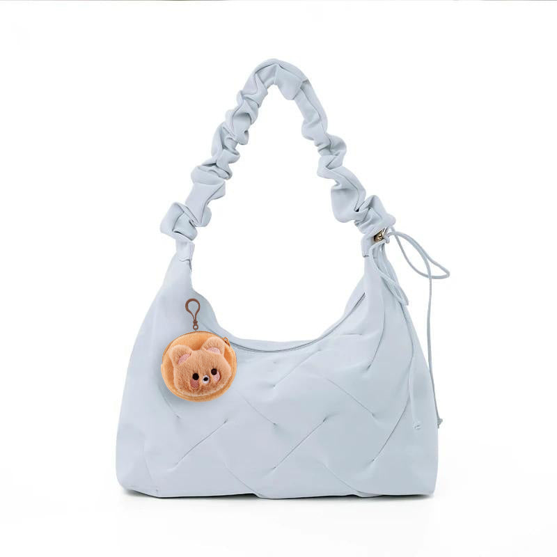Light blue ruched shoulder bag with a cute bear charm and quilted pattern.