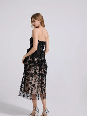 Black strapless midi dress with intricate floral applique and sheer overlay.