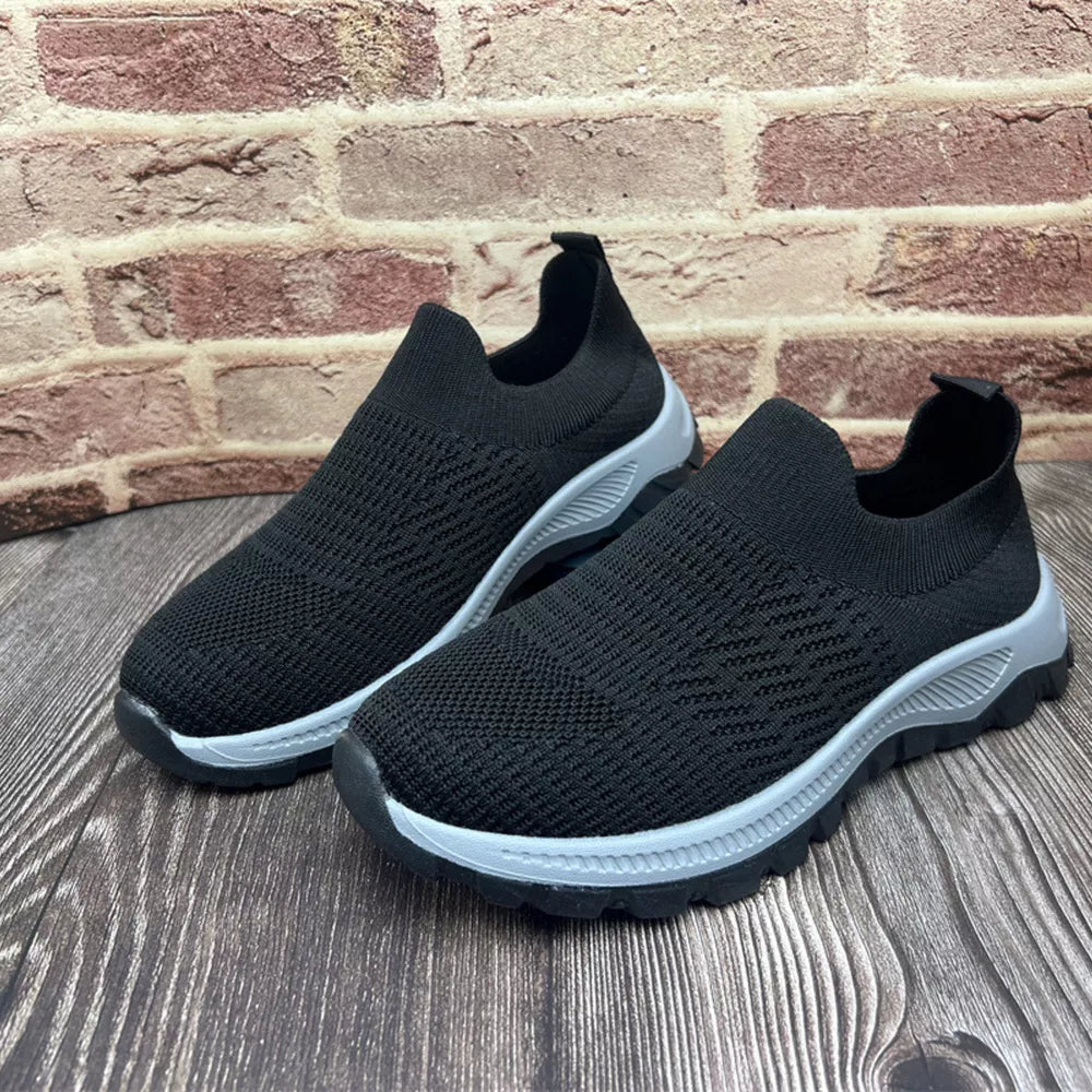 Black breathable round toe slip-on sneakers with grey soles