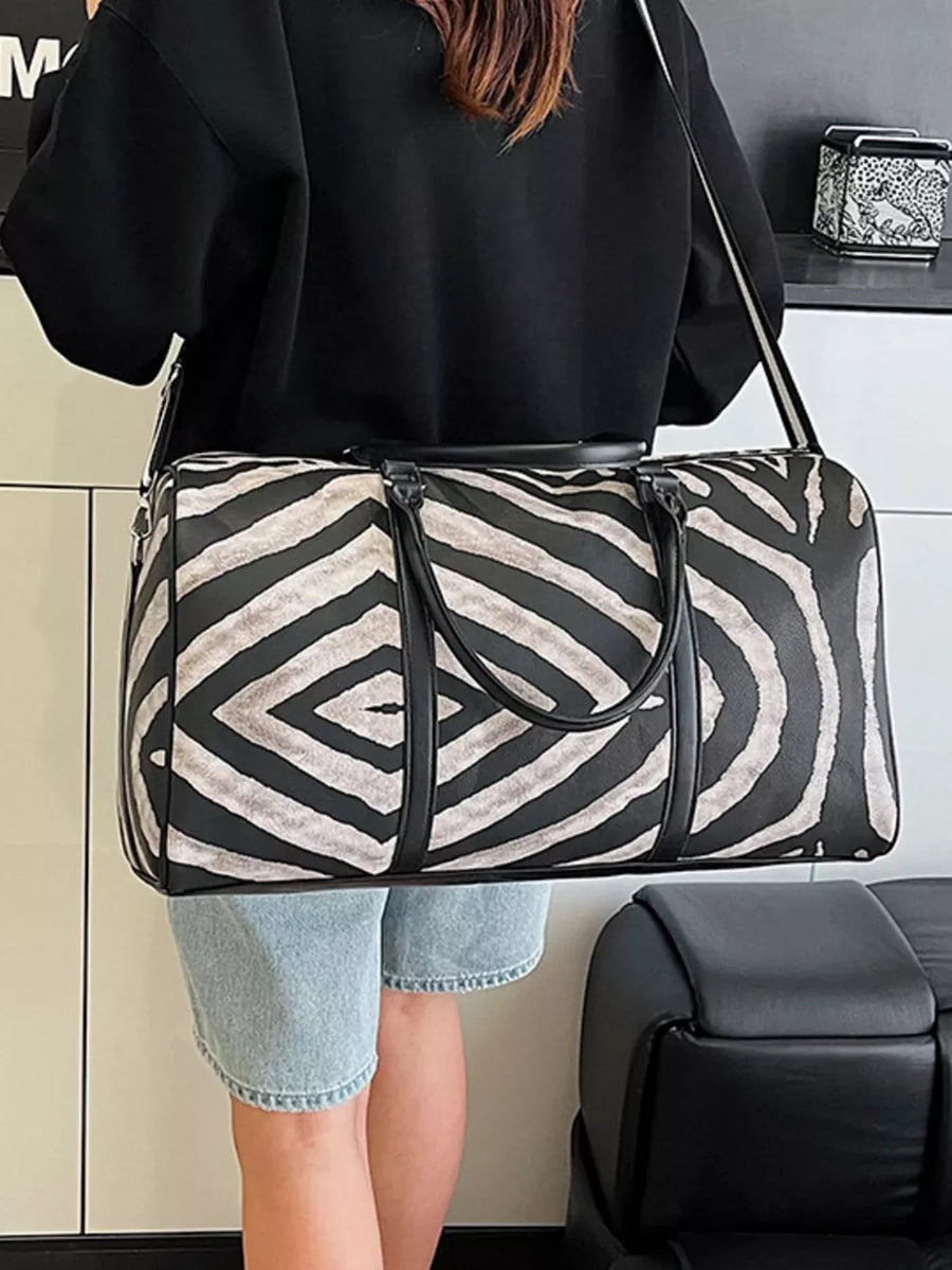 Large black and white zebra print duffle bag with carry handles and detachable strap.