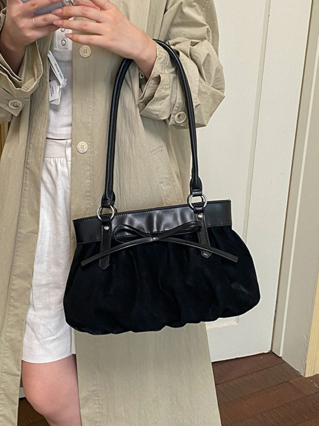 shoulder bag in black featuring bow detail and structured fit