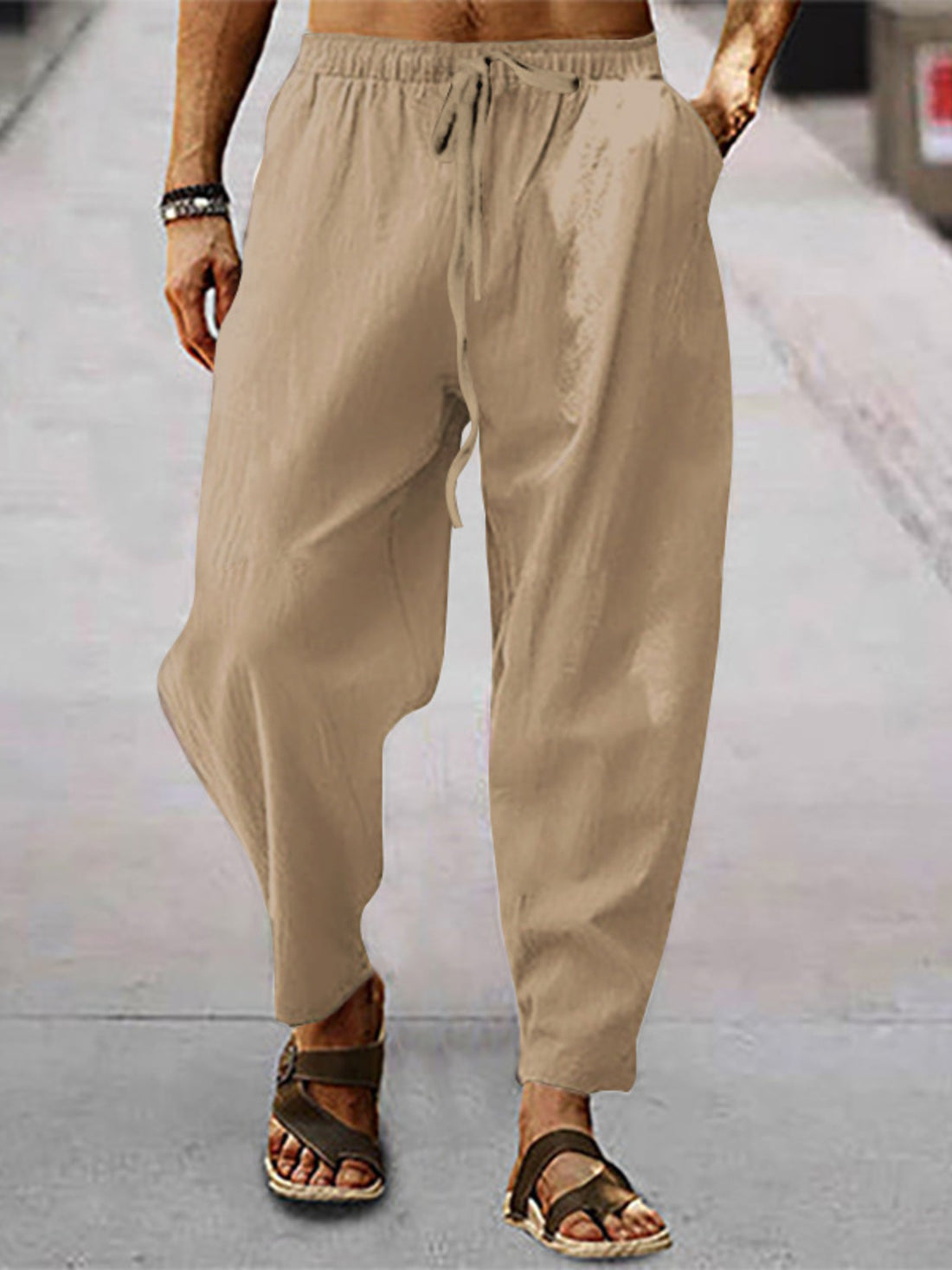 Men's khaki drawstring wide leg sweatpants with pockets.