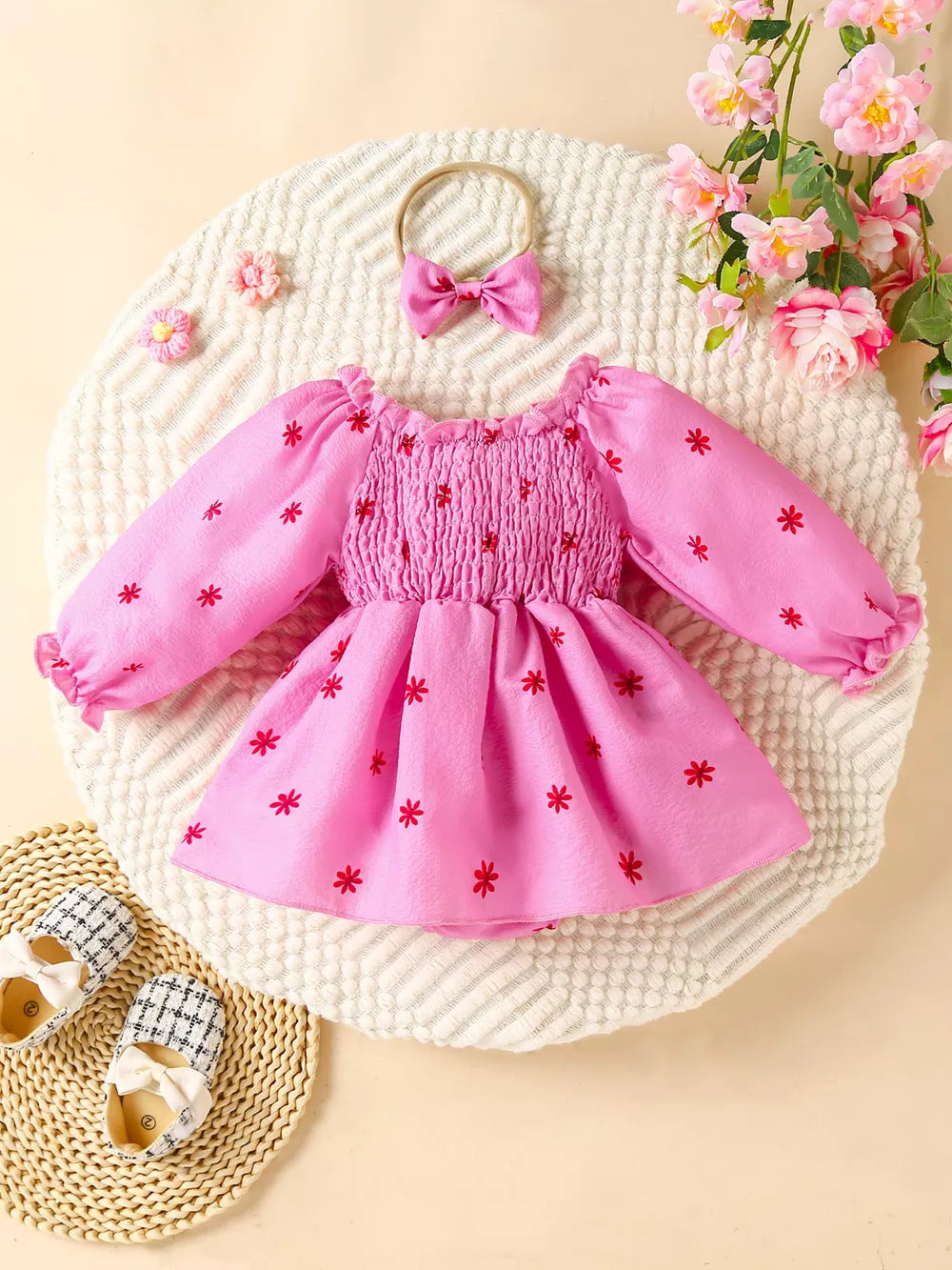 Pink floral smocked baby dress set with long sleeves and matching bow headband.