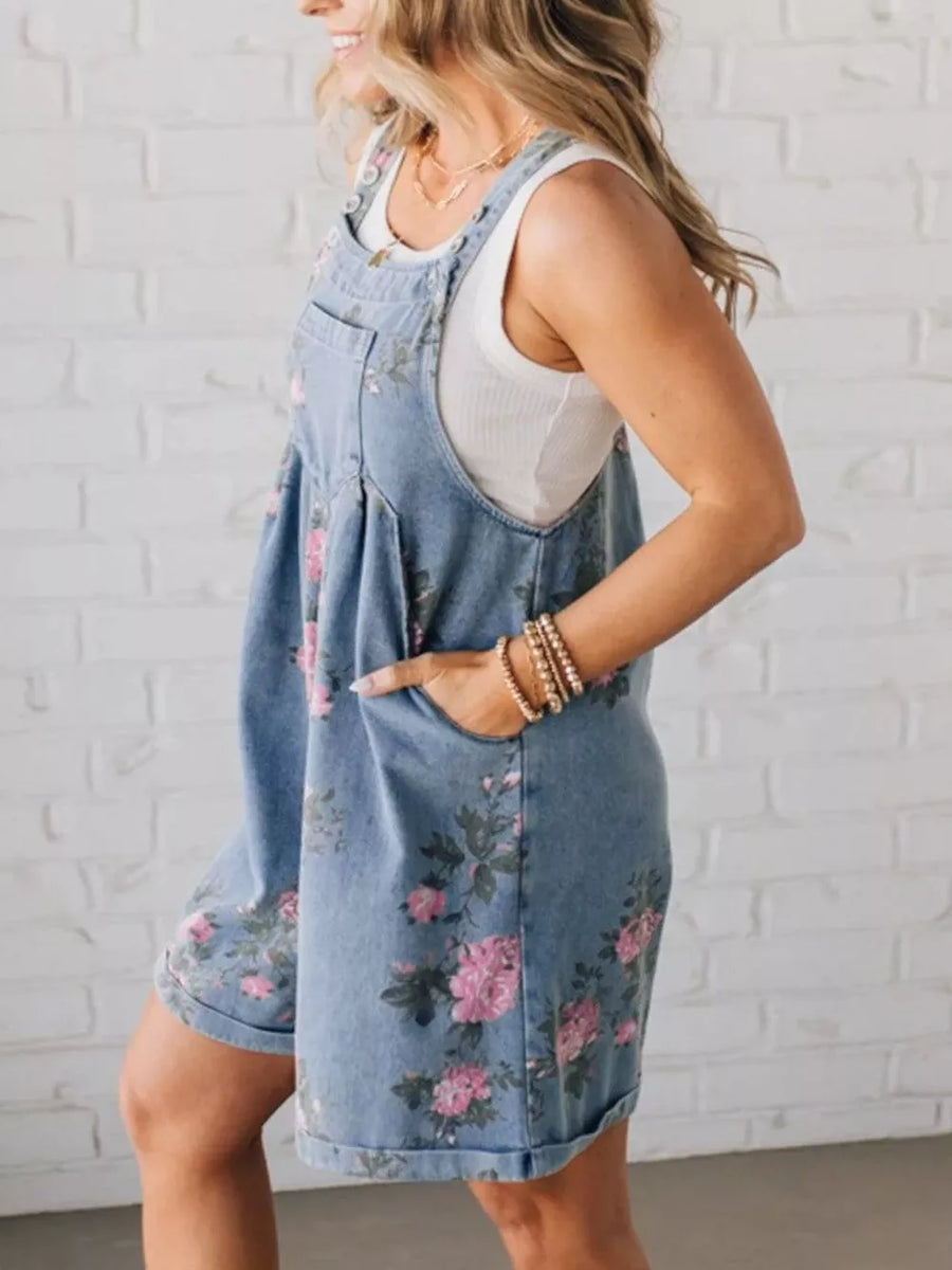 Denim overalls shorts with pink floral print and cuffed hem.