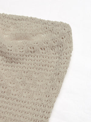 Beige knit maxi dress with intricate openwork pattern and cutout detail.