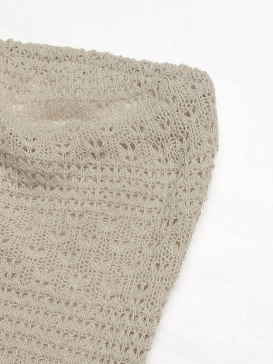 Beige knit maxi dress with intricate openwork pattern and cutout detail.