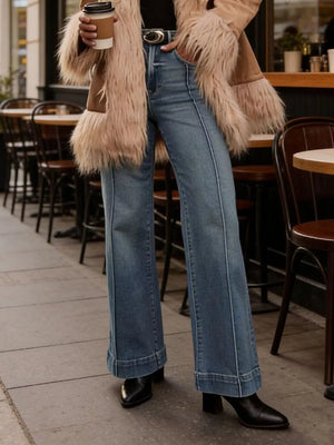 Elevated high-waisted flare jeans in blue denim with contrast stitching and a wide leg.