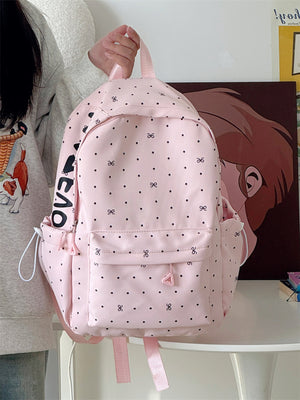 Pink polka dot backpack with bowknot pattern and front pocket detail.