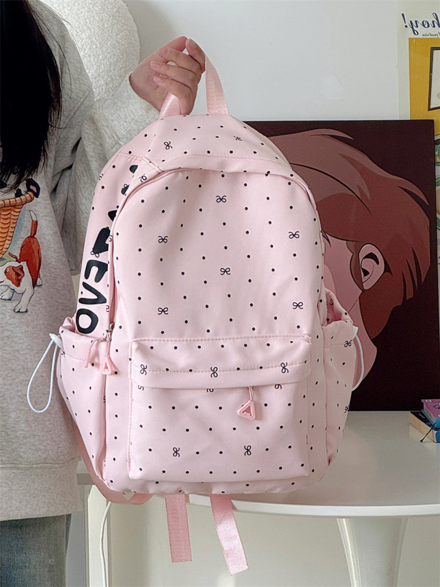 Pink polka dot backpack with bowknot pattern and front pocket detail.