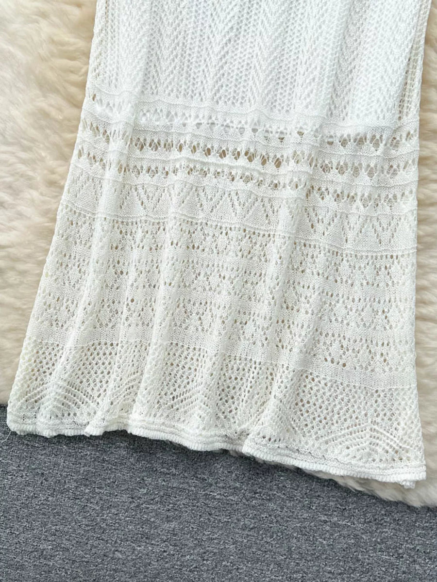 White openwork maxi skirt with intricate knit patterns and a flowing hem.