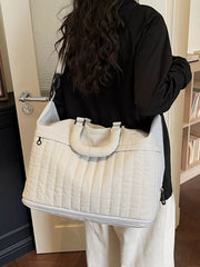 Chic quilted nylon travel bag in cream white with adjustable strap and top handles.