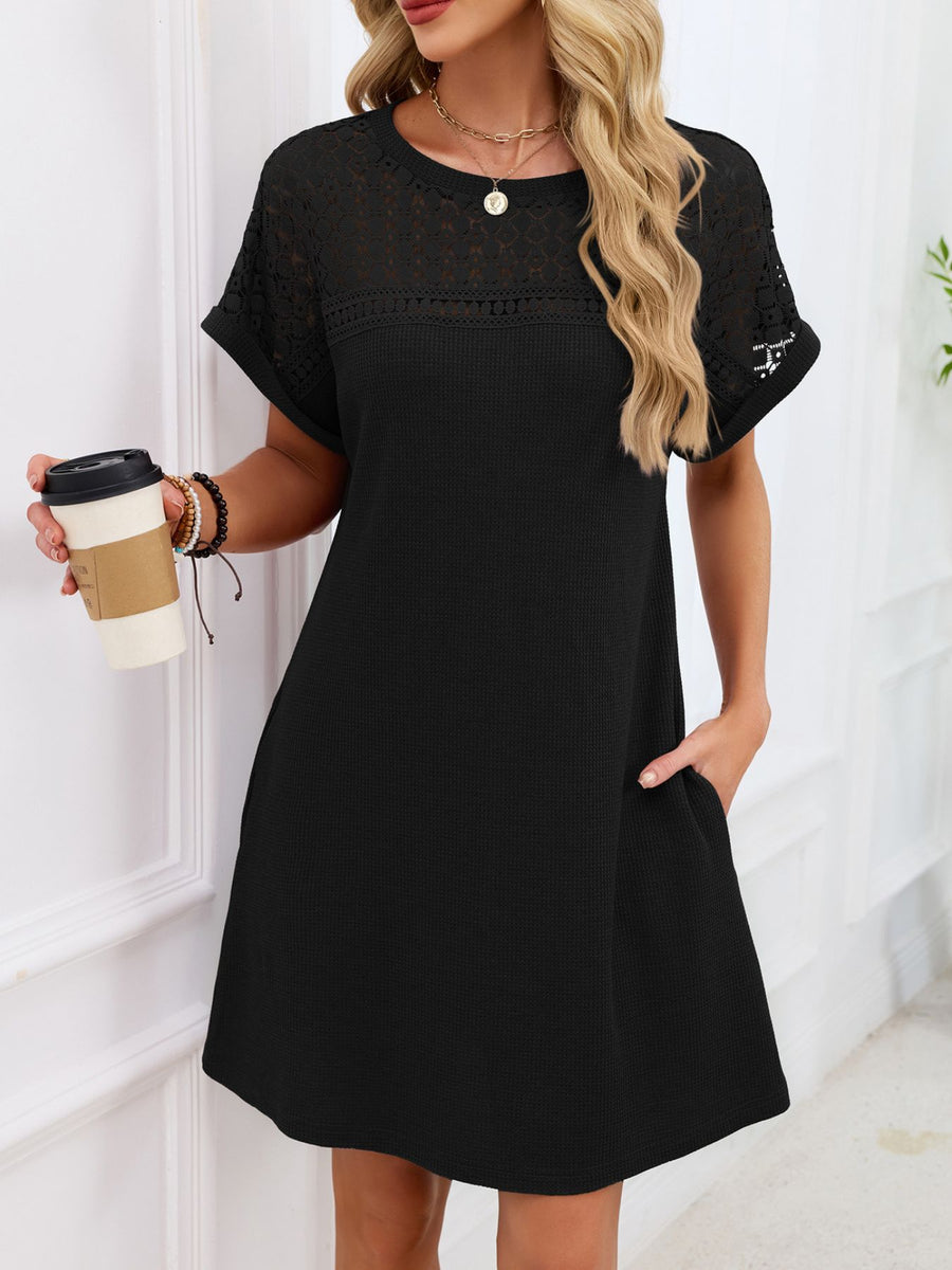 Black t-shirt dress with sheer lace yoke and short sleeves, above knee length.