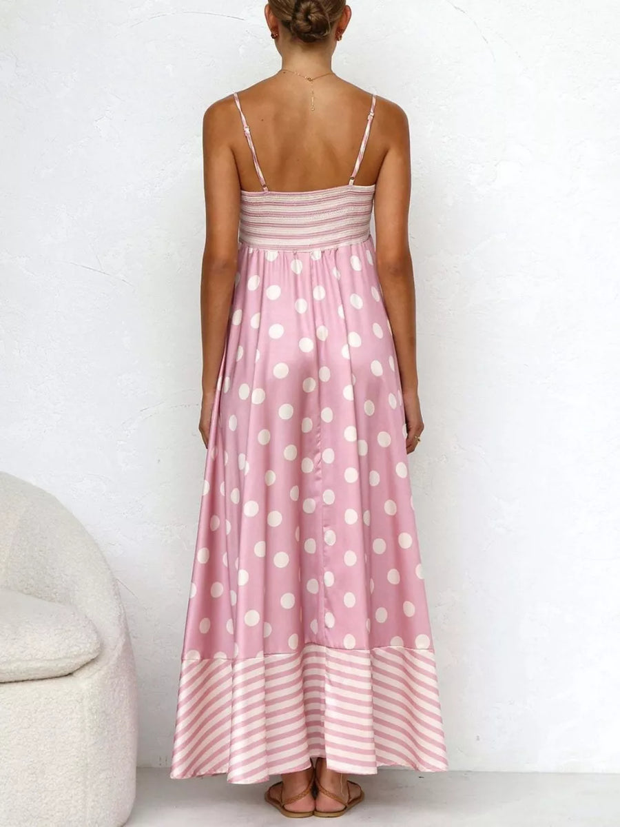 Blush pink polka dot maxi dress with spaghetti straps, smocked bodice, and striped hem.