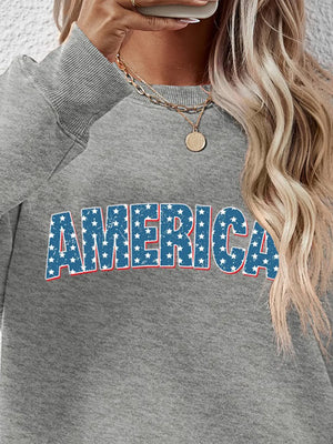 Grey crewneck sweatshirt with America graphic featuring blue stars and red trim