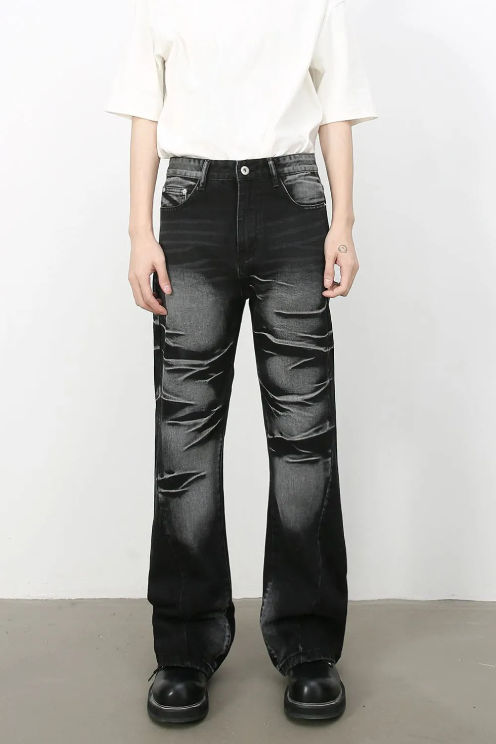 Distressed flare denim jeans in dark shadow wash with a bootcut leg.