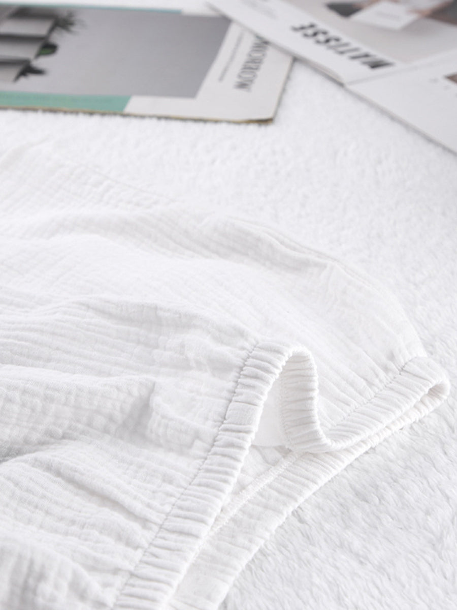 White cotton pajama shorts with textured fabric and elastic waistband