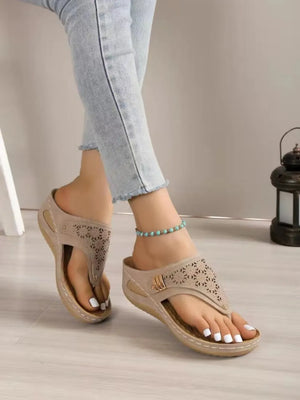 Laser-cut comfort thong sandals in khaki with decorative floral patterns and adjustable strap.