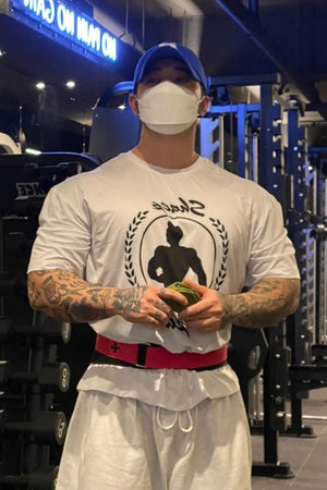 White graphic oversized tee with a bold circular logo and short sleeves.