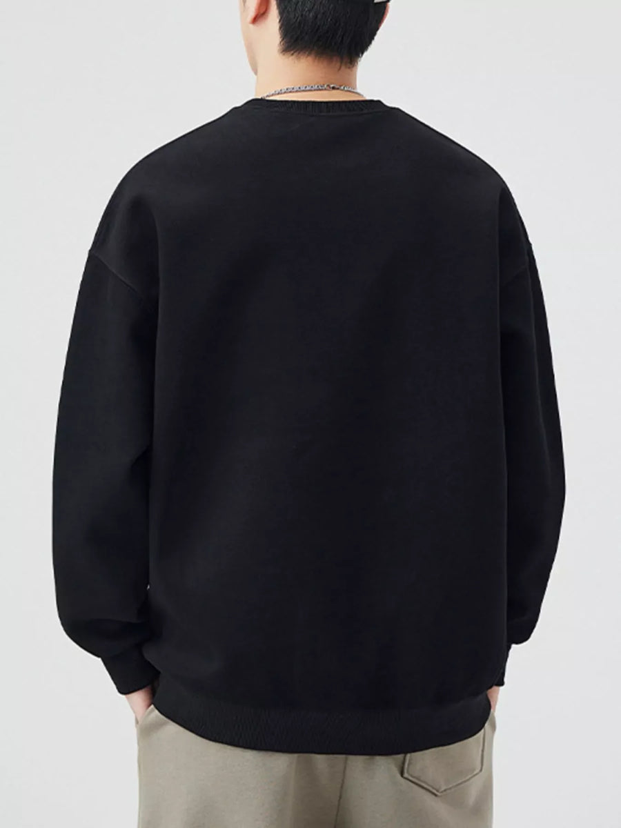 Black oversized crew-neck sweatshirt with long sleeves and ribbed cuffs and hem.