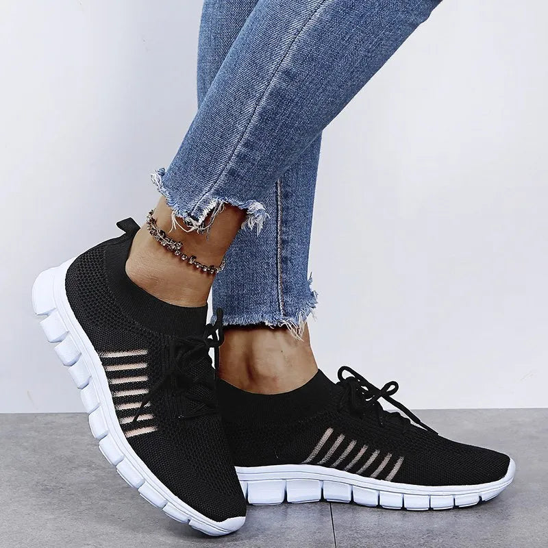 Black knit runner sneakers with ribbed lace-up detail and white soles.