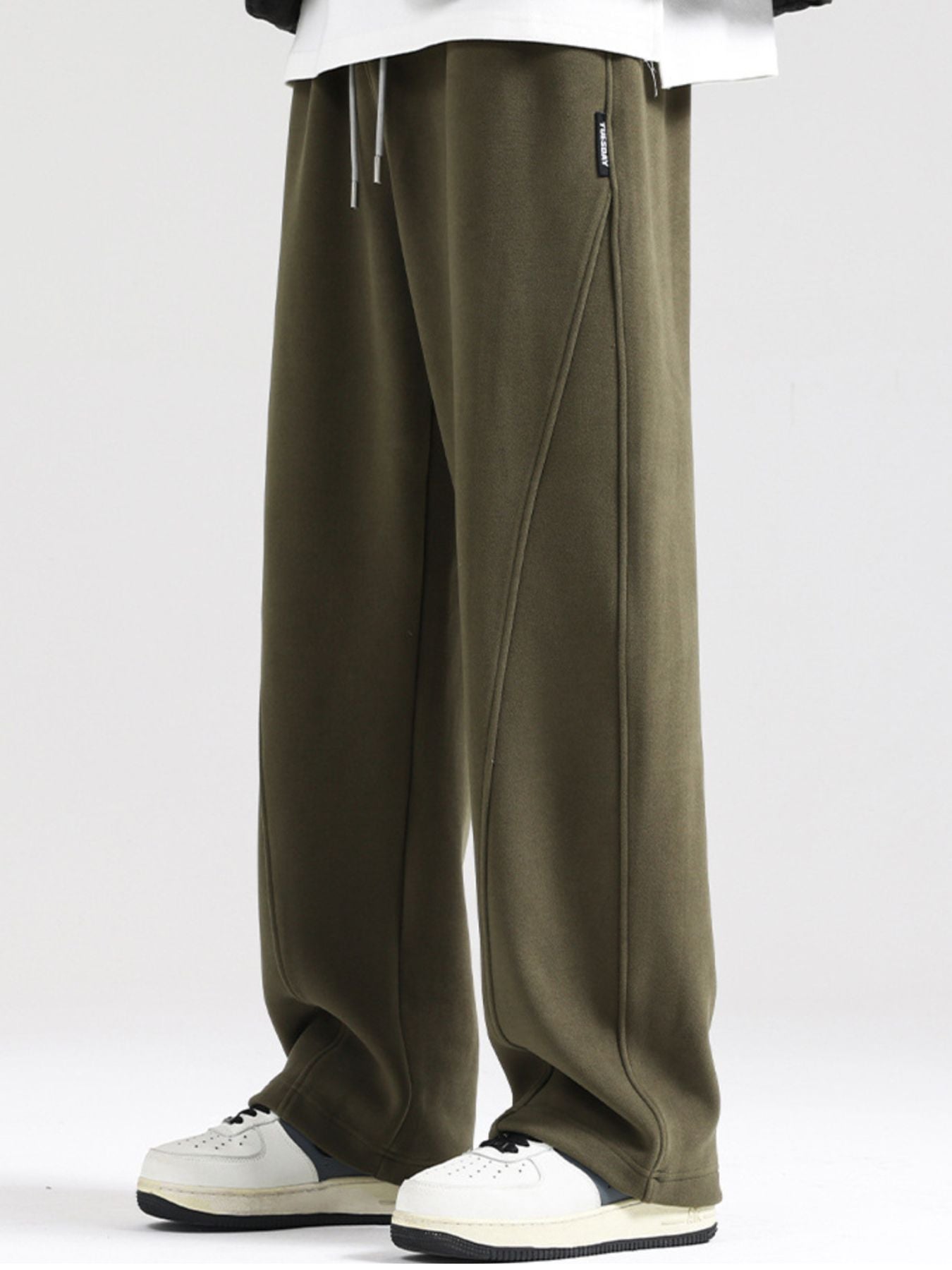 Men's army green wide-leg sweatpants with drawstring waist and seam detail.