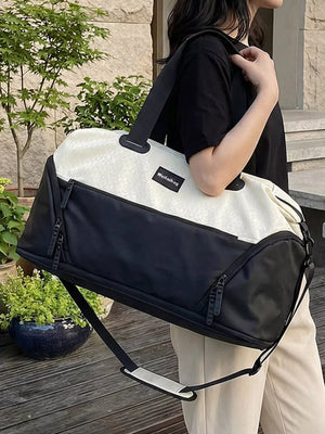 Textured two-tone large duffle bag in black and cream with adjustable strap.