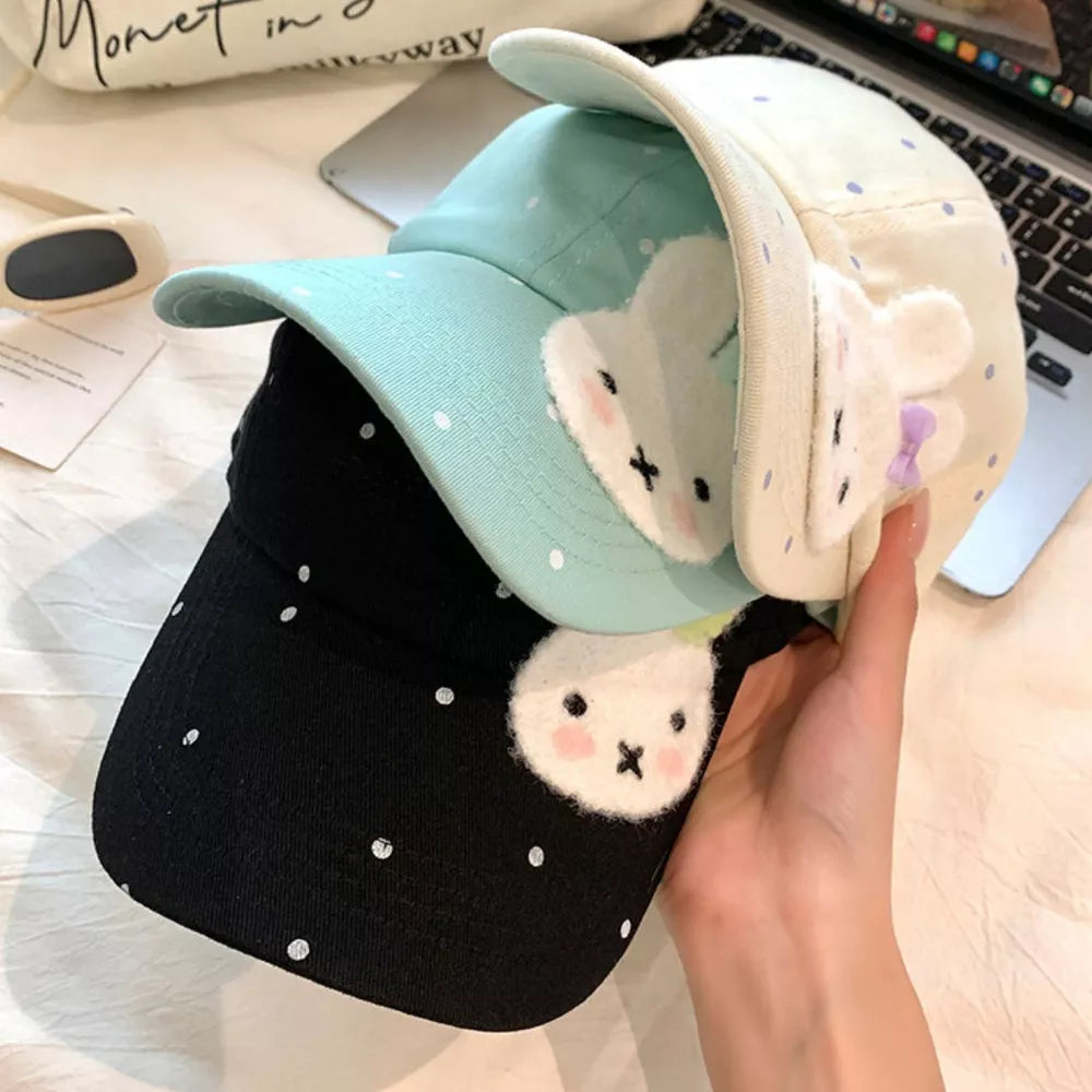 Baby baseball cap with bunny applique and polka dots in black, pastel blue, and ivory.
