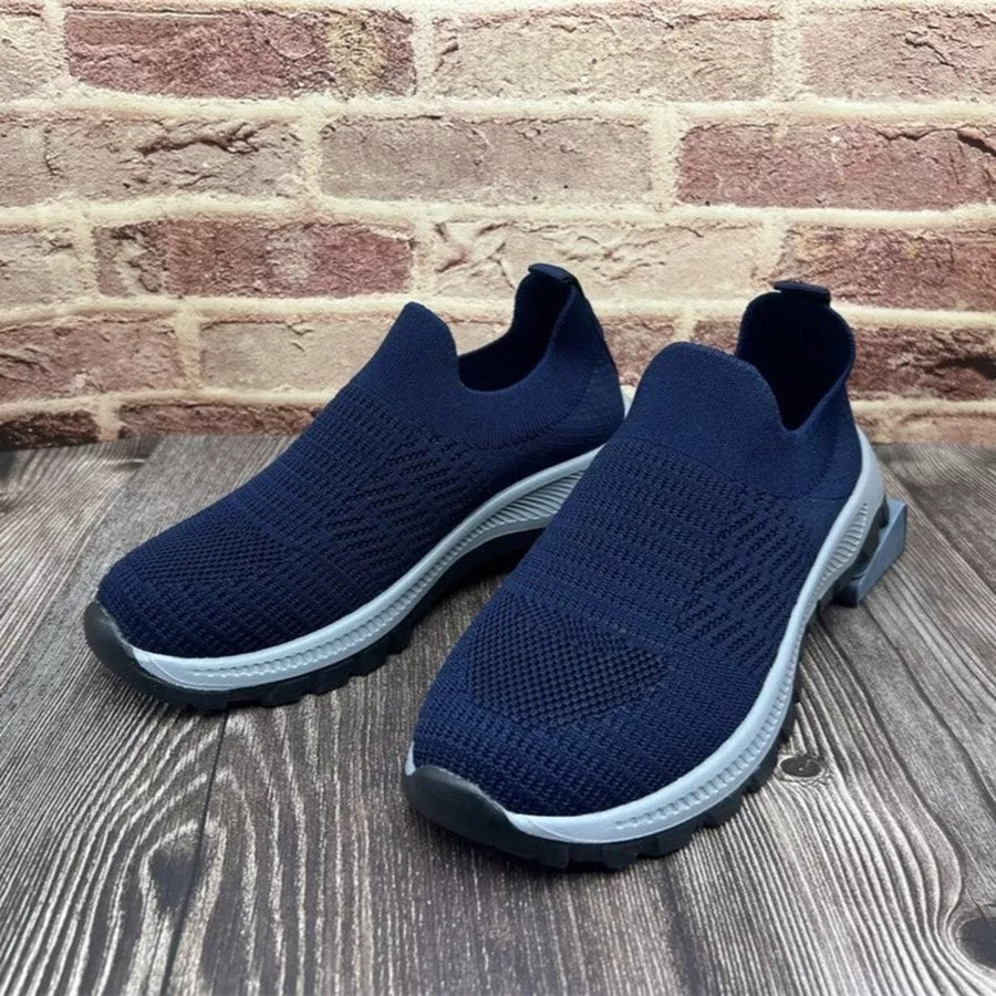 Blue breathable round toe slip-on sneakers with a textured knit upper and light grey sole.