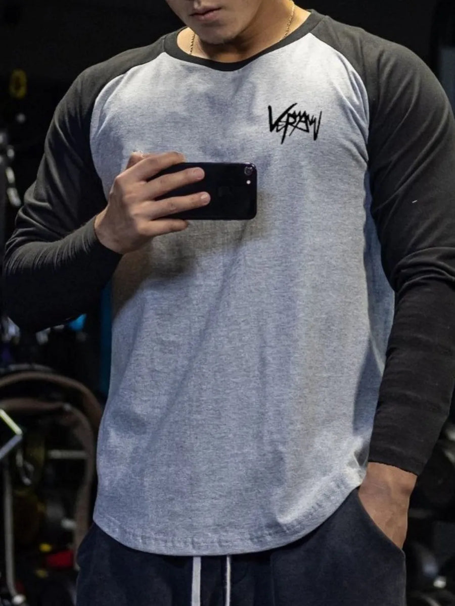 Raglan sleeve graphic tee in gray with black sleeves and a black graphic logo on the chest.