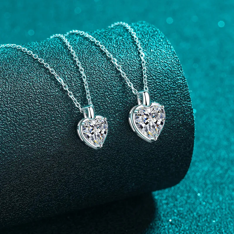 Silver heart cut moissanite pendant necklace on a delicate chain.