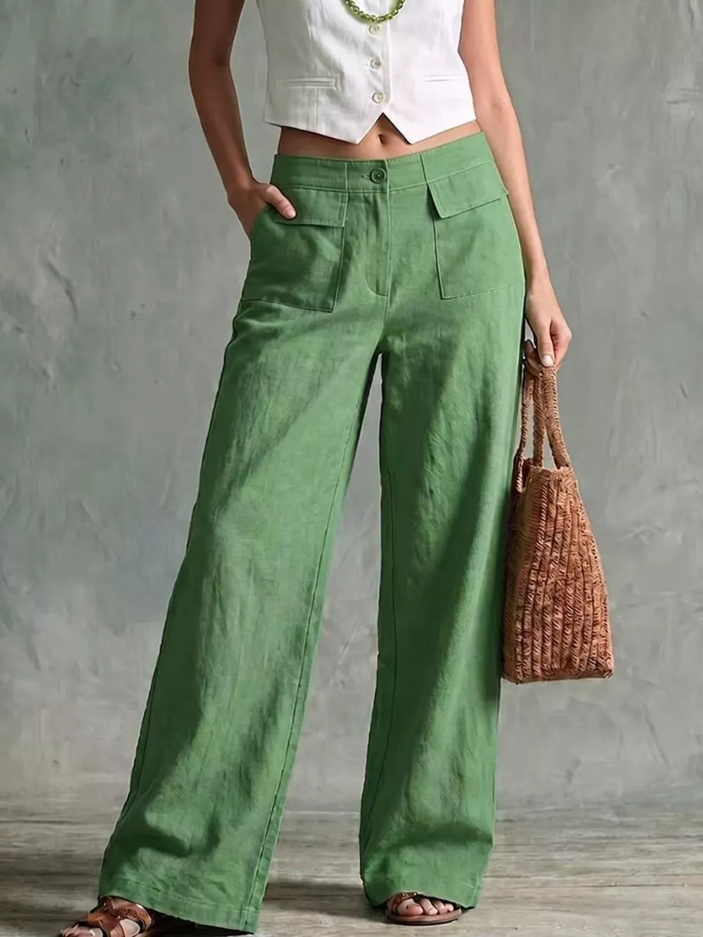Green linen wide-leg pants with flap pockets and a high waist.