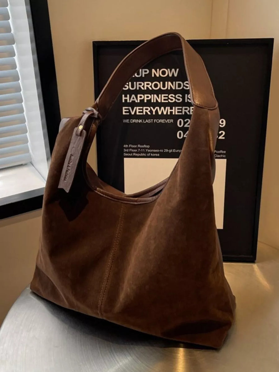 Brown plush corduroy hobo shoulder bag with leather strap and tag detail