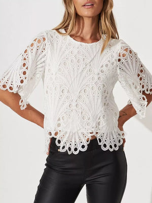 White lace half-sleeve blouse with intricate eyelet and scalloped hem detail.