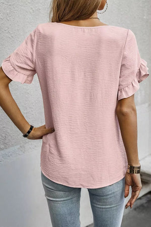 Blush pink polyester blouse with short ruffled sleeves and textured fabric.