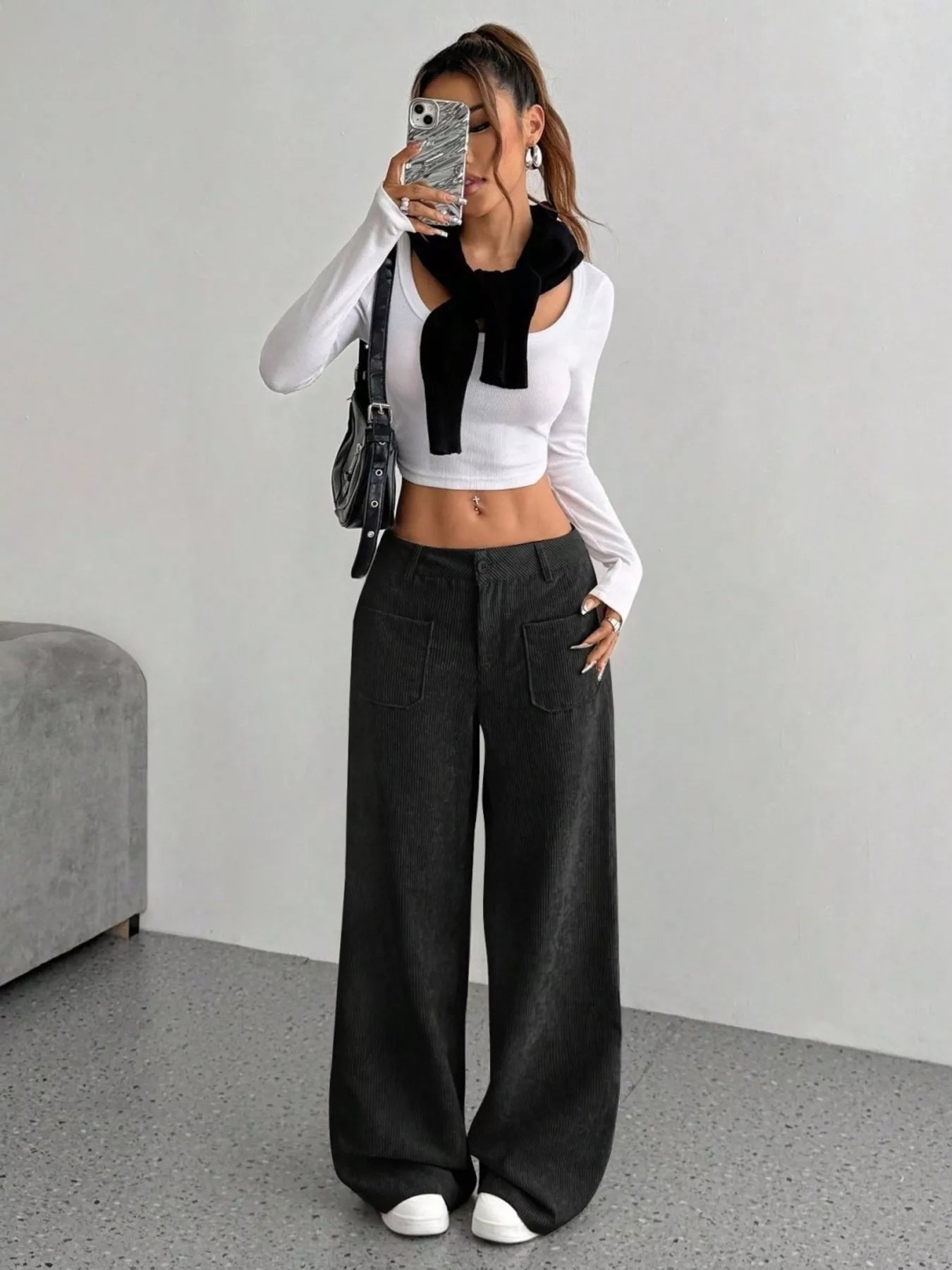Chic wide-leg corduroy trousers in black with front pockets, styled casually.